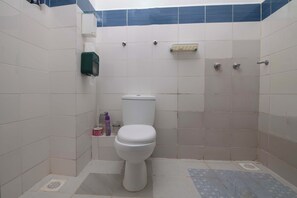 Ein Badezimmer mit Toilette, Handtrockner und Seifenspender.