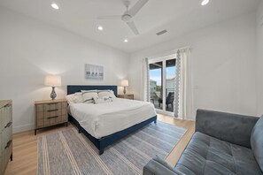 A bedroom with a bed, bedside tables, a ceiling fan, a large window with curtains, and a view of the outside. - New 30A Home | Gulf View, Hot Tub, Golf Cart | Pet Friendly | Fall Specials! (Santa Rosa Beach)