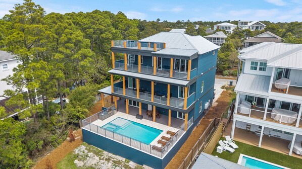 A multi-story building with a rooftop pool and outdoor seating. - New 30A Home | Gulf View, Hot Tub, Golf Cart | Pet Friendly | Fall Specials! (Santa Rosa Beach)