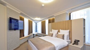 A modern hotel room with a large bed, bedside tables, a TV, and a wardrobe. - North Gate Avenue (Yerevan)
