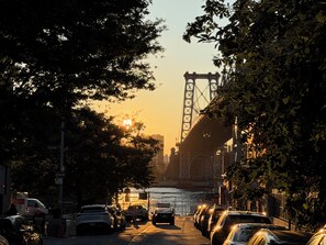 Vista de la calle con coches aparcados, un puente y una masa de agua.