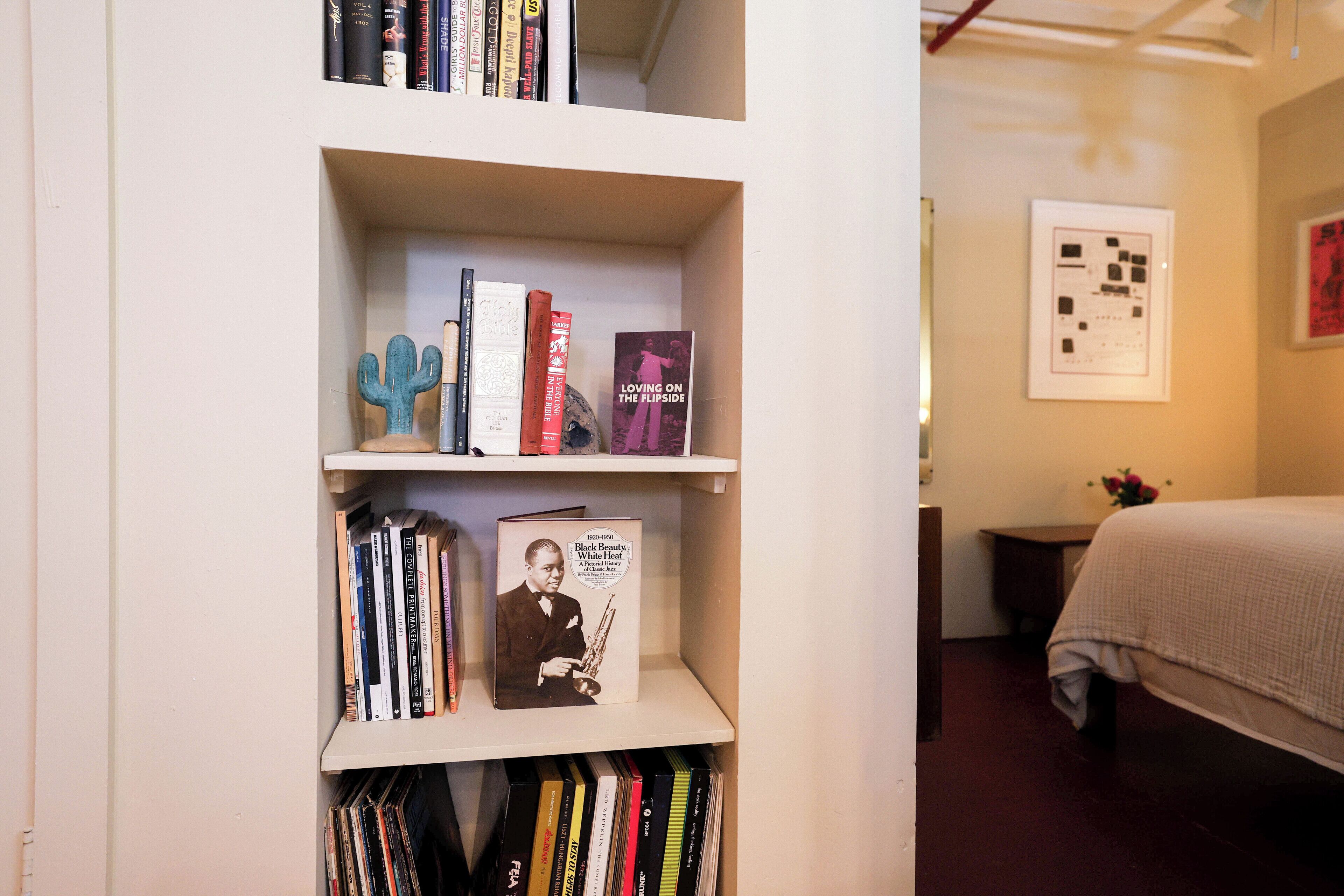 Una libreria con libri e un quadro incorniciato.