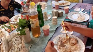 A group of people dining at a table with various dishes, drinks, and a potted plant. - At 900 mt. Spa, 1 km the sea, Oltremare/Aquafan, 10 min. walk, 5 min. by bike (Riccione)