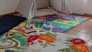 A child's play area with a tent, colorful mats, and a bed with floral bedding. - At 900 mt. Spa, 1 km the sea, Oltremare/Aquafan, 10 min. walk, 5 min. by bike (Riccione)