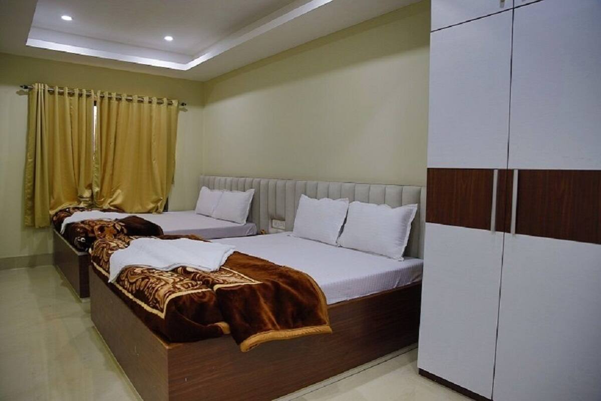 Een slaapkamer met twee bedden, een kledingkast en een plafondlamp.