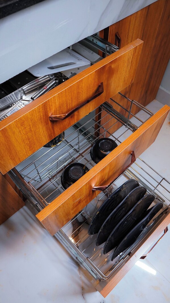A kitchen with wooden cabinets, a stainless steel sink, and a built-in dishwasher drawer. - We We Wayanad- Casa de Wayanad (Sulthan Bathery)