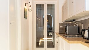 A modern kitchen with white cabinets, a wooden countertop, and a built-in oven.