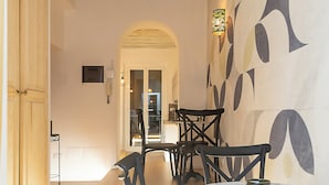 A modern interior with wooden floors, black chairs, and a white table.