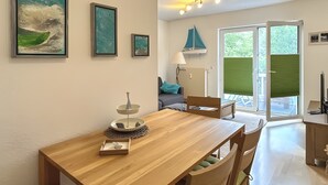 A dining area with a wooden table, green cushioned chairs, and a decorative centerpiece.
