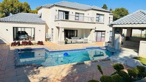 A two-story house with a swimming pool, a garage, and a covered outdoor seating area. - The Hide in Sandton (Sandton)