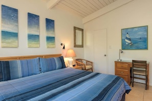 A bedroom with a bed, a desk, a chair, and three paintings on the wall. - Tiki 208 - 1br Condo With Balcony And Smart Tv 1 Bedroom Condo (South Padre Island)