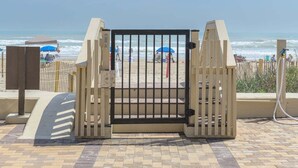 A gated entrance to a beach area with a tiled walkway leading to the sea. - Tiki 325 - Family Friendly Oceanview Condo Sleep 6 1 Bedroom Condo (South Padre Island)