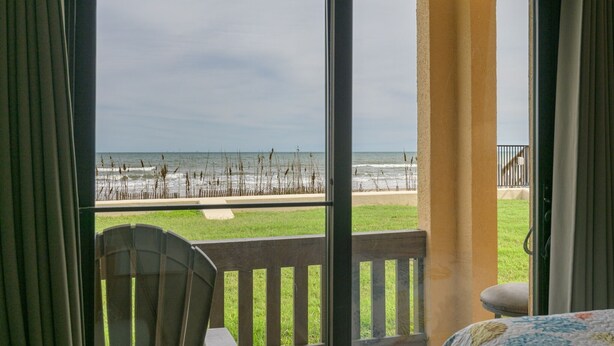 A room with a view of the beach, a chair, and a bed. - Tiki 128 - Spacious Ocean View 1br Condo Sleeps 6 1 Bedroom Condo (South Padre Island)