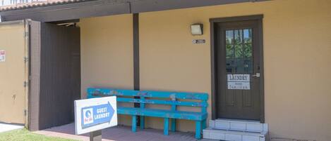 Un cuarto de lavandería para huéspedes con un cartel que indica el horario de funcionamiento.