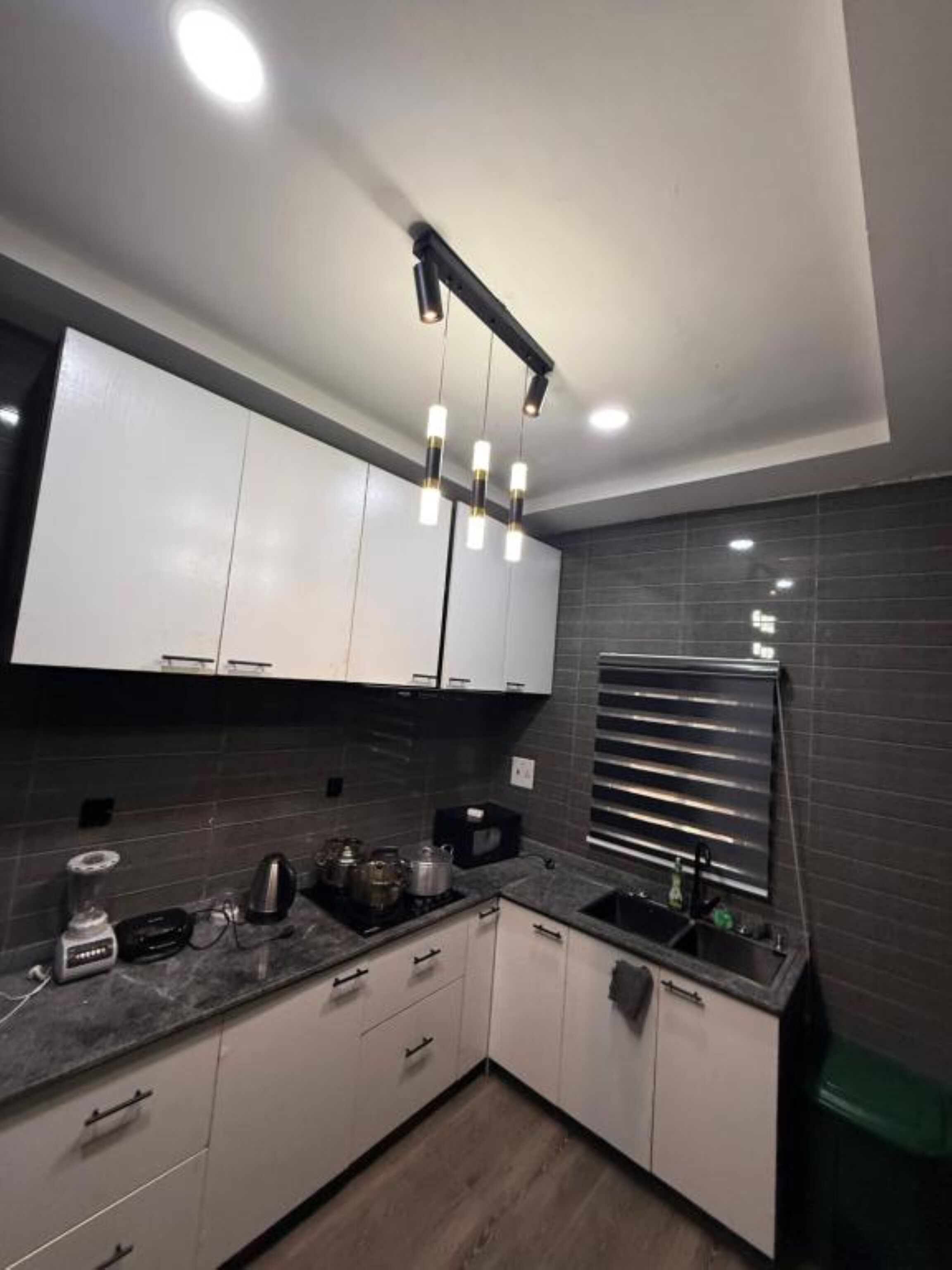 A modern kitchen with white cabinets, a black countertop, and a built-in oven.