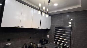 A modern kitchen with white cabinets, a black countertop, and a built-in oven.