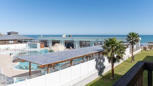 Ett semesterhotell med poolområde, en inglasad terrass och utsikt över havet.
