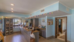 Una cocina con una isla central, un refrigerador y una ventana.