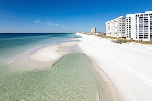 Un hotel frente a la playa con una playa de arena y vista al océano.