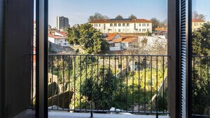Un balcone con vista su edifici e alberi.