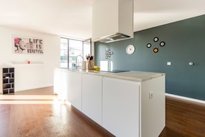 A modern kitchen with white cabinets, a built-in stove, and a backsplash with decorative plates. - Guest H4U - Bonjardim Pop Art (Porto)