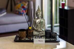 A Buddha statue, incense burners, and a sign reading "GuestHouse4U" on a table. - Guest H4U - Bonjardim Pop Art (Porto)