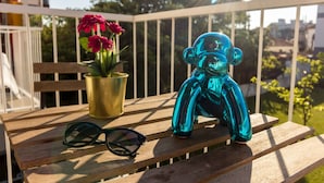 A wooden bench with a pair of sunglasses and a blue glass figurine on it. - Guest H4U - Bonjardim Pop Art (Porto)