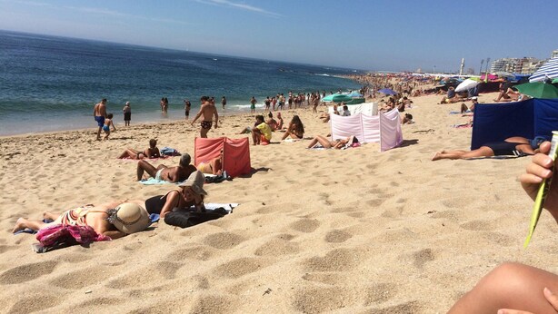 A crowded beach with people sunbathing and walking along the shore. - Guest House 4U - Povoa Seaside (Povoa De Varzim)