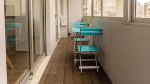 A narrow corridor with sliding glass doors, a wooden floor, and a small table with chairs.