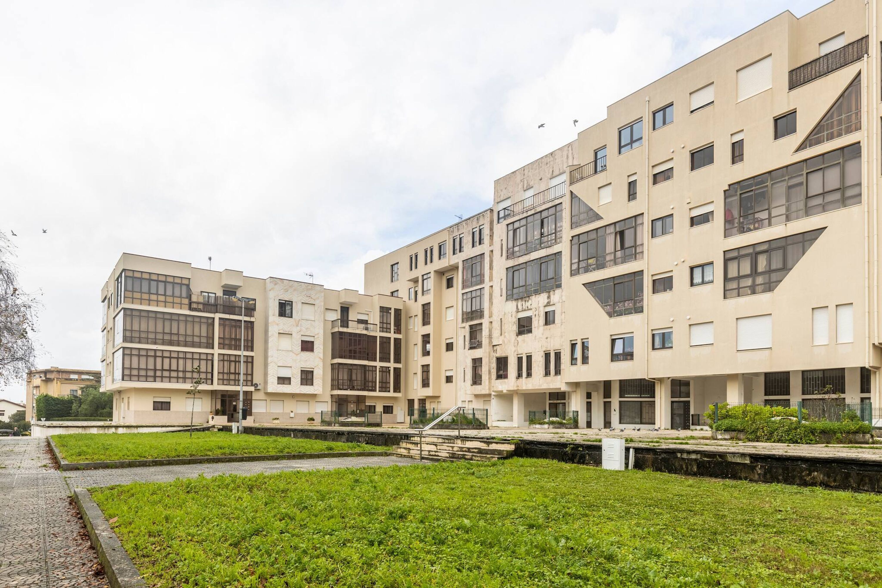 Un immeuble à plusieurs étages doté d’une architecture moderne, avec des balcons et de grandes fenêtres.