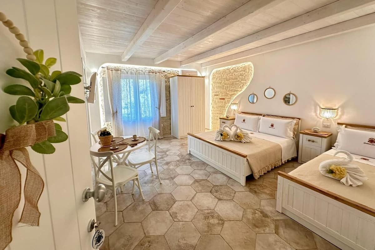 A bedroom with a bed, bedside tables, a mirror, and a window with curtains.