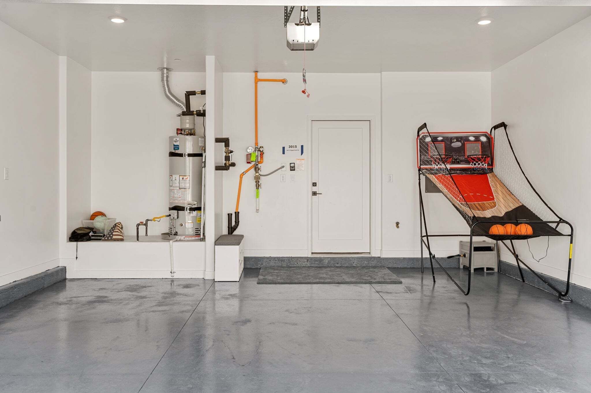 A room with a white door, a basketball hoop, and a water dispenser.