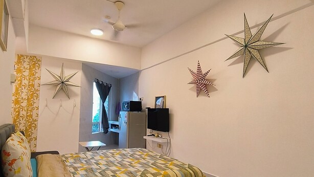 Ein Schlafzimmer mit einem Bett, einem Schreibtisch, einem Stuhl und einem Deckenventilator.