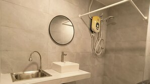 Ein modernes Badezimmer mit Waschbecken, Spiegel und Dusche.