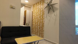 Ein modernes Wohnzimmer mit einer Couch, einem kleinen Tisch, einem dekorativen Stern an der Wand und einer Wandtapete mit Muster.
