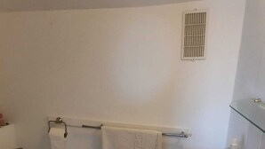Un baño con inodoro, lavamanos y zona de ducha.