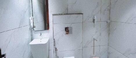 Ein Badezimmer mit Waschbecken, Toilette und Duschbereich.