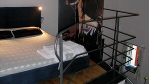 Un lit superposé avec une tête de lit, une affiche accrochée au mur et une fenêtre avec des rideaux.