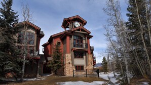 A large, multi-story building with a prominent clock tower, surrounded by trees and snow. - Marina Park Mountain View Townhome: Heart of Frisco (Frisco)