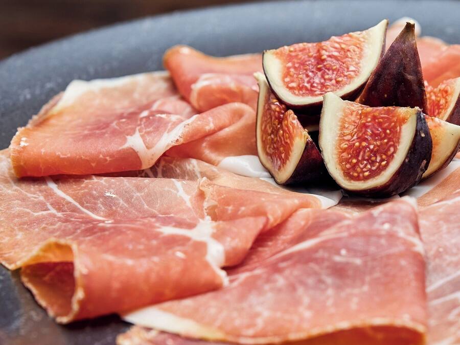 Une assiette de jambon de Parme en tranches et de figues.