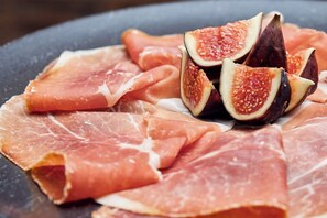 A plate with sliced prosciutto and figs. - Hotel Höfli (Altdorf)