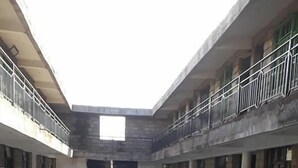 Une cour intérieure dotée d’un espace central ouvert, entourée de bâtiments pourvus de balcons et de fenêtres.