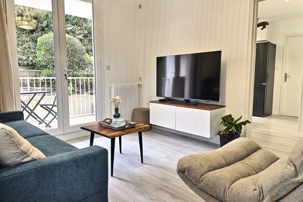 Le coin salon avec baie-vitrée donnant sur la terasse privative