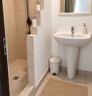 Un bagno con doccia, lavandino e toilette.
