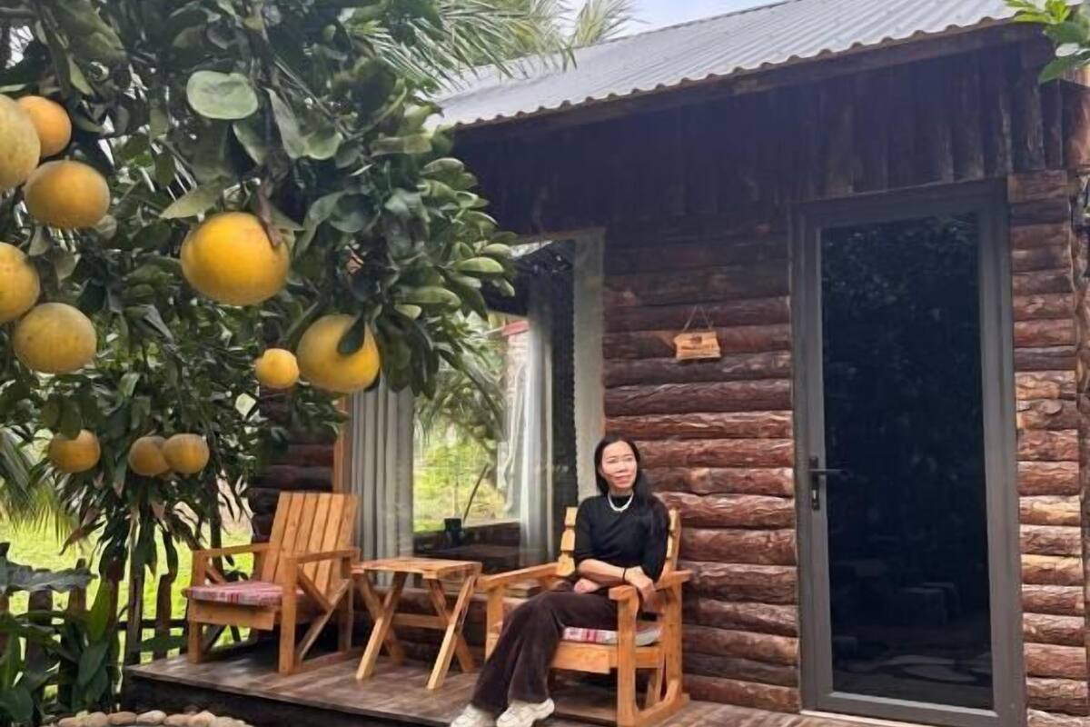 Un chalet rustique avec un sentier de pierres menant à des chaises et une table en bois.