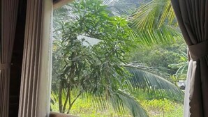A room with wooden flooring, a window with curtains, and an air conditioning unit. - Wood Haven Homestay (Hoa Lu)