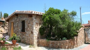 A stone building with a tiled roof, a door, and a window. There are potted plants and a tree in front. - Detached cottage with spaiggia within walking distance, sea d mountain view! (Santa Maria Navarrese)