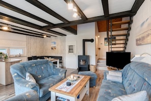 Una sala de estar moderna con un sofá, una mesa de centro, una chimenea y una escalera.