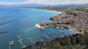 Un pueblo costero con un puerto deportivo, edificios históricos y una vista despejada del mar.