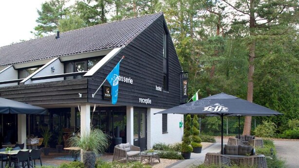A hotel with a black and white exterior, a reception area with outdoor seating, and a sign for 'Leffe'. - Spacious Ground-floor Apartment in Lochem (Lochem)